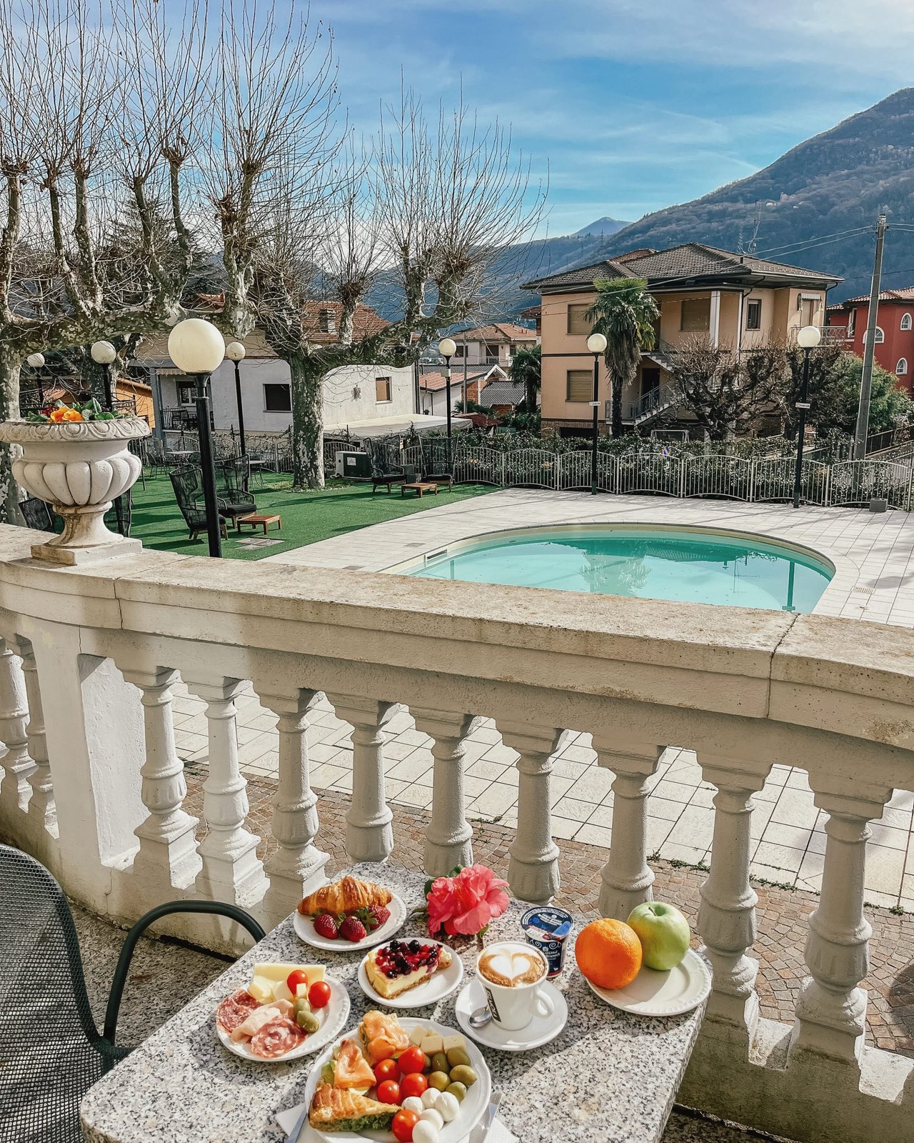 La colazione sulla balaustra in pietra sopra la piscina, oltre le montagne.