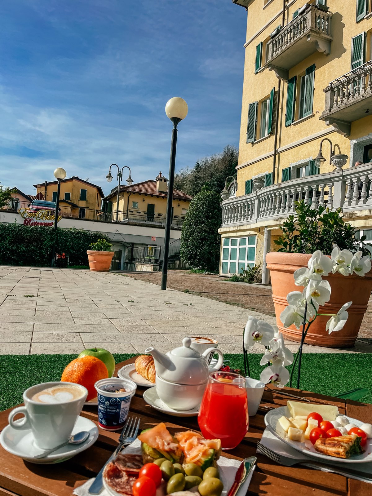 The yellow facade with its balconies, a garden lamp, breakfast in the foreground.